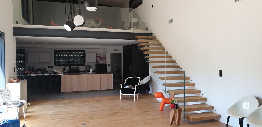 Escalier droit en bois teinté blanc sans contremarches garde-corps en verre Treppenmeister